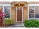 Charming front door with 'hello' mat, surrounded by lush landscaping and bright windows at 624 51St N Ave, St Petersburg, FL 33703