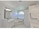 Clean white bathroom featuring a soaking tub under a window and updated vanity at 6332 35Th Avenue E Cir, Palmetto, FL 34221
