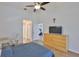 Bedroom with wood flooring, a ceiling fan, and a wooden dresser underneath a wall mounted tv at 6332 35Th Avenue E Cir, Palmetto, FL 34221
