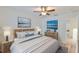 Well-lit bedroom with a comfortable bed, lamps, and scenic artwork displayed on the wall at 6332 35Th Avenue E Cir, Palmetto, FL 34221