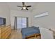 Cozy bedroom with wood floors, natural light from sliding glass doors, and a ceiling fan at 6332 35Th Avenue E Cir, Palmetto, FL 34221