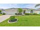 Charming single-story home featuring a well-manicured lawn, tropical plants, and a two-car garage at 6332 35Th Avenue E Cir, Palmetto, FL 34221