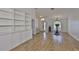 Bright, open living room with hardwood floors, built-in shelving, and transom window above entry door at 6332 35Th Avenue E Cir, Palmetto, FL 34221