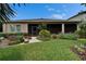 Charming backyard featuring a screened patio entrance surrounded by vibrant landscaping and green lawn at 6507 Maiden Sea Dr, Apollo Beach, FL 33572