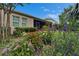 Lush landscaping borders the home's screened in porch and the backyard features a variety of colorful plants and bushes at 6507 Maiden Sea Dr, Apollo Beach, FL 33572