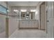 Bright bathroom featuring double sinks with granite countertops, modern fixtures, and a large glass-enclosed shower at 6507 Maiden Sea Dr, Apollo Beach, FL 33572