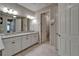 Bright bathroom with granite counters, double sinks, white cabinetry, and tile flooring at 6507 Maiden Sea Dr, Apollo Beach, FL 33572