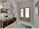 Charming foyer with a decorative mirror, elegant console table, and inviting double doors at 6507 Maiden Sea Dr, Apollo Beach, FL 33572