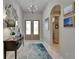 Inviting entryway with chandelier lighting, stylish mirror and console table, and tiled flooring at 6507 Maiden Sea Dr, Apollo Beach, FL 33572