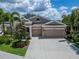Beautiful single-story home showcasing a three car garage, well manicured landscaping, and a neutral color palette at 6507 Maiden Sea Dr, Apollo Beach, FL 33572