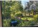 Inviting view from the lanai showcases a beautiful landscaped garden with flowers, green grass, and a variety of plants and trees at 6507 Maiden Sea Dr, Apollo Beach, FL 33572