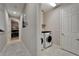 View down a hallway into an office and laundry room featuring neutral paint colors and tile flooring at 6507 Maiden Sea Dr, Apollo Beach, FL 33572