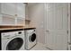 Convenient laundry area with modern washer and dryer, featuring storage cabinets and a folding counter at 6507 Maiden Sea Dr, Apollo Beach, FL 33572