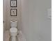 Neat half bath featuring a standard toilet with tiled floors, white paint, and decorations at 6507 Maiden Sea Dr, Apollo Beach, FL 33572