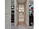 Open walk-in closet featuring shelving units with folded clothing and closet area that leads to the bathroom at 6507 Maiden Sea Dr, Apollo Beach, FL 33572