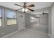 Open-concept living room with gray walls, ceiling fan, tile flooring, and plenty of natural light at 6601 13Th N St, St Petersburg, FL 33702