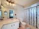 Bathroom with a sink, toilet, decorative birch-themed shower curtain, and a large mirror at 7237 Bramblewood Dr, Port Richey, FL 34668