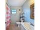 Bathroom featuring a vanity with storage, toilet, and framed mirror and shower with pink curtains at 7237 Bramblewood Dr, Port Richey, FL 34668