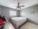 This bedroom features tiled floors, a ceiling fan, and a neutral color scheme, perfect for relaxation at 7237 Bramblewood Dr, Port Richey, FL 34668
