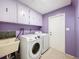 Bright laundry room with modern appliances, utility sink, and ample cabinet space at 7237 Bramblewood Dr, Port Richey, FL 34668