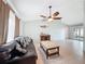 Spacious living room with tile floors, couch, and sliding door to the outside at 7237 Bramblewood Dr, Port Richey, FL 34668