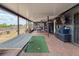 View of a covered patio featuring a hammock, grill, dining set, and an entertainment area at 7237 Bramblewood Dr, Port Richey, FL 34668