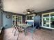 Covered patio featuring a ceiling fan, outdoor dining set, refrigerator, and dartboard at 7237 Bramblewood Dr, Port Richey, FL 34668