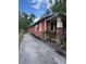 Red home exterior showing side yard and driveway under a blue sky at 7807 N Mulberry St, Tampa, FL 33604