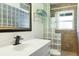 Bright bathroom featuring a glass block shower, modern vanity, and decorative mirror at 7842 15Th N Way, St Petersburg, FL 33702