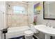 Cozy bathroom with tiled walls, tub, and pedestal sink at 7842 15Th N Way, St Petersburg, FL 33702