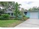 Charming single-story home featuring a quaint front porch, manicured yard landscaping, a private driveway and a garage at 7842 15Th N Way, St Petersburg, FL 33702
