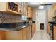 Galley kitchen showcasing granite counters, stainless steel appliances, and decorative backsplash at 7842 15Th N Way, St Petersburg, FL 33702