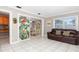 Bright living room featuring tile flooring, a leather sofa, and views into the dining area and kitchen at 7842 15Th N Way, St Petersburg, FL 33702
