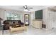 Cozy living area showcasing tile flooring, a ceiling fan, a comfortable sofa, and an interior door to the dining area at 7842 15Th N Way, St Petersburg, FL 33702