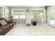 Relaxing living room with a leather sofa, tile flooring, and ample natural light from the windows at 7842 15Th N Way, St Petersburg, FL 33702