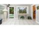 Sunlit living room with a door leading to a pool area, tile floors, and neutral tones, creating a bright atmosphere at 7842 15Th N Way, St Petersburg, FL 33702