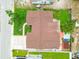 Aerial view of house with brown roof and green yard in residential neighborhood with a driveway and street parking at 8225 Medford Dr, Port Richey, FL 34668