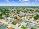 Extensive aerial view showcasing a vibrant residential area with diverse housing styles, green spaces, and a serene pond at 8225 Medford Dr, Port Richey, FL 34668
