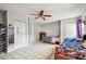Bedroom with tile floors, ceiling fan, two beds, and closet doors at 8225 Medford Dr, Port Richey, FL 34668