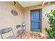 Welcoming front porch with tiled floor, seating, and a charming blue door, complete with decorative accents at 8225 Medford Dr, Port Richey, FL 34668