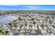 Overhead view of the residential neighborhood with homes lining the lake and lush greenspace in the distance at 8407 Hunters Fork Loop, Ruskin, FL 33573