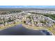 A high-angle aerial showing homes on a waterfront property with a sprawling lake wrapping the community at 8407 Hunters Fork Loop, Ruskin, FL 33573