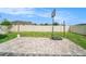 Backyard with paver patio, basketball hoop, grassy area, and white fence at 8407 Hunters Fork Loop, Ruskin, FL 33573