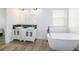 Bathroom features dual sinks, a soaking tub, and tile flooring at 8407 Hunters Fork Loop, Ruskin, FL 33573