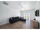 Cozy living room featuring a large sectional, TV, and sliding door to a screened in porch at 8407 Hunters Fork Loop, Ruskin, FL 33573