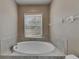 Large soaking tub under a window in the bathroom at 925 Windton Oak Dr, Ruskin, FL 33570