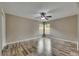 Spacious bedroom featuring wood-look floors, a ceiling fan, and natural light from two windows at 925 Windton Oak Dr, Ruskin, FL 33570