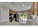 Well-lit kitchen featuring wooden cabinets, black appliances, and a sliding door to the backyard at 925 Windton Oak Dr, Ruskin, FL 33570