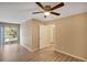 Bedroom featuring light wood flooring, a ceiling fan, and balcony access at 9414 Lake Chase Island Way # 9414, Tampa, FL 33626