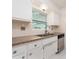 Kitchen with neutral countertops, white cabinets, and stainless steel dishwasher at 949 Virginia St, Dunedin, FL 34698